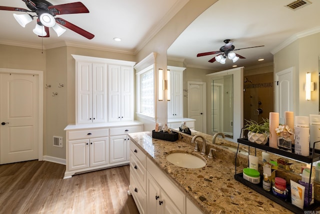 bathroom featuring a shower stall, visible vents, wood finished floors, and ceiling fan