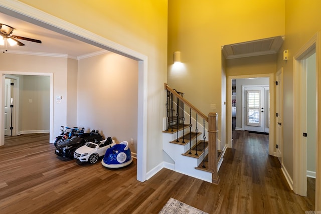 entryway featuring crown molding, baseboards, a ceiling fan, and wood finished floors