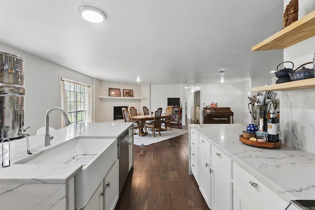 kitchen featuring open floor plan, open shelves, white cabinets, dark wood finished floors, and a sink