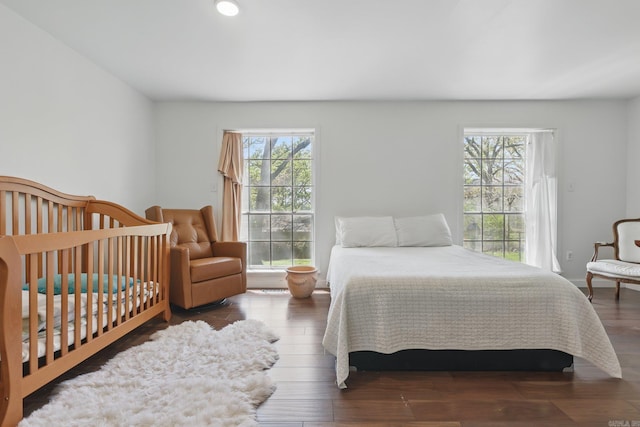 bedroom with multiple windows and wood finished floors
