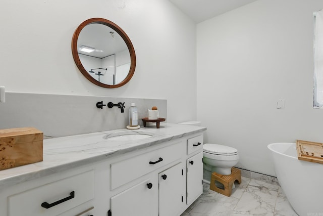 bathroom featuring a freestanding tub, vanity, marble finish floor, and toilet