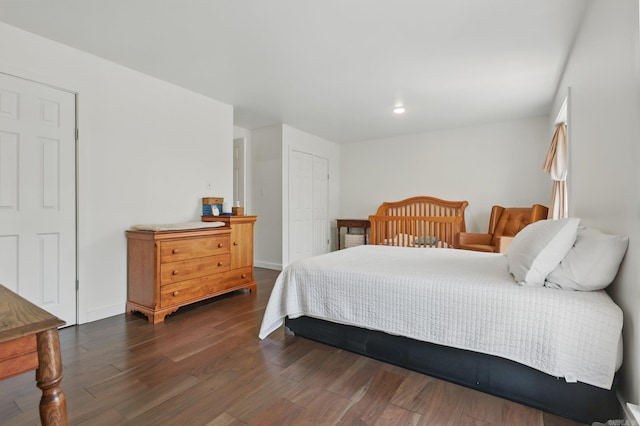 bedroom featuring dark wood-style floors, a closet, and baseboards
