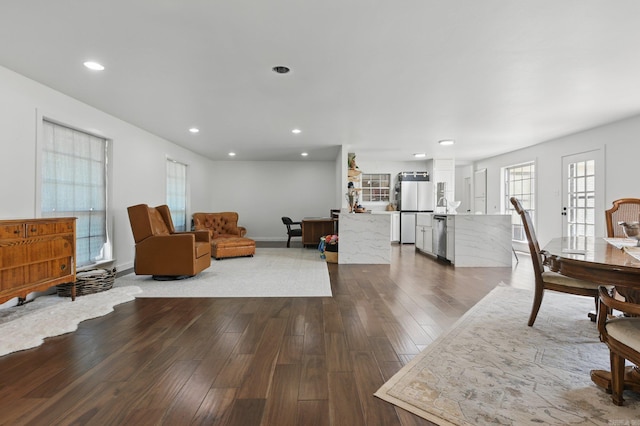 living area with dark wood-style flooring, baseboards, and recessed lighting