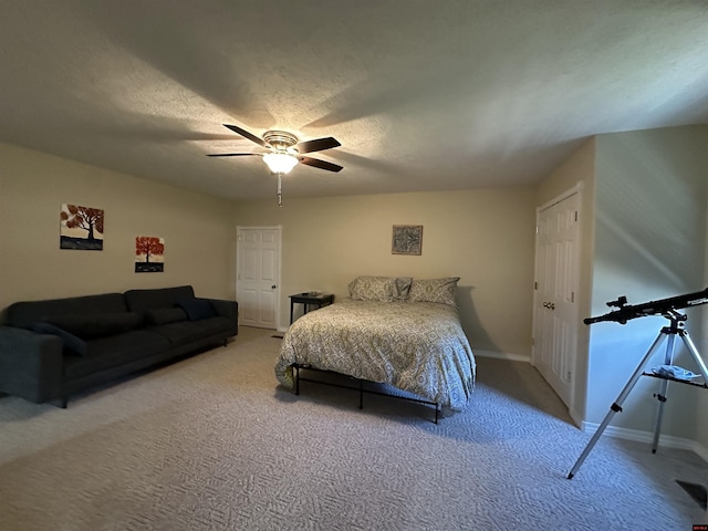 bedroom with a textured ceiling, ceiling fan, baseboards, and carpet