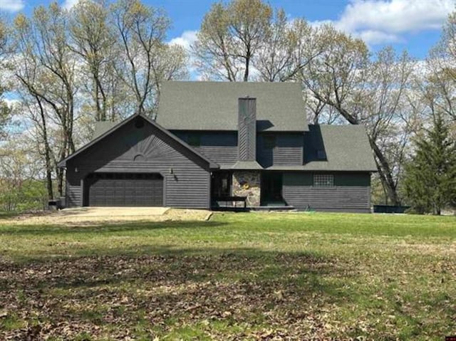 view of front of house featuring a front lawn, a garage, and a chimney