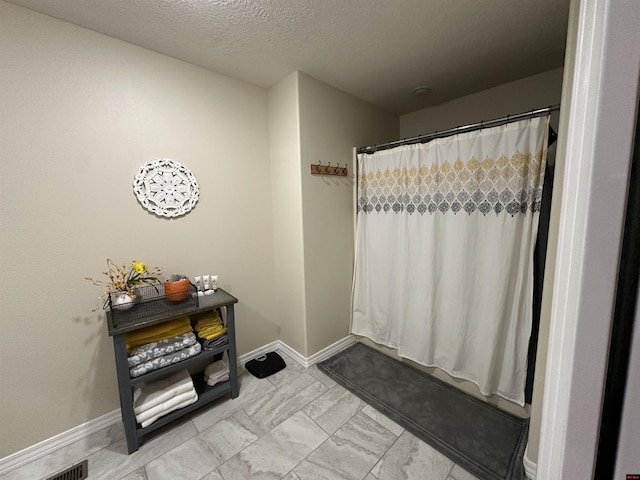 full bath with visible vents, marble finish floor, baseboards, and a shower with curtain