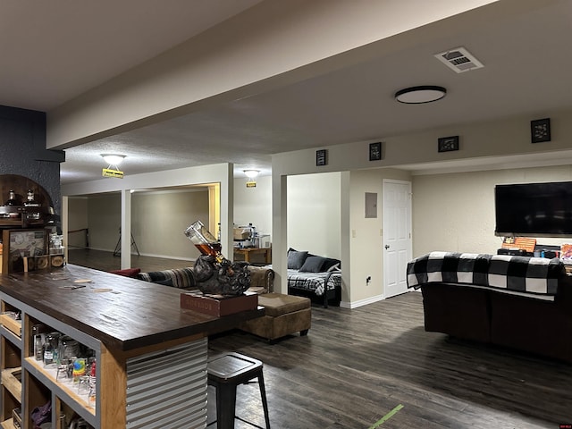 living area with baseboards, dark wood finished floors, and visible vents