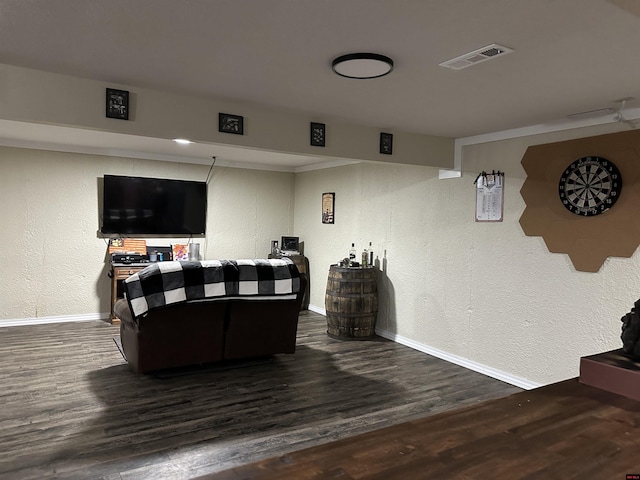 living room with visible vents, baseboards, and wood finished floors