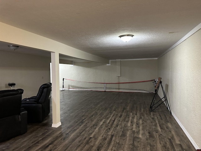 finished basement with a textured wall, baseboards, and dark wood finished floors
