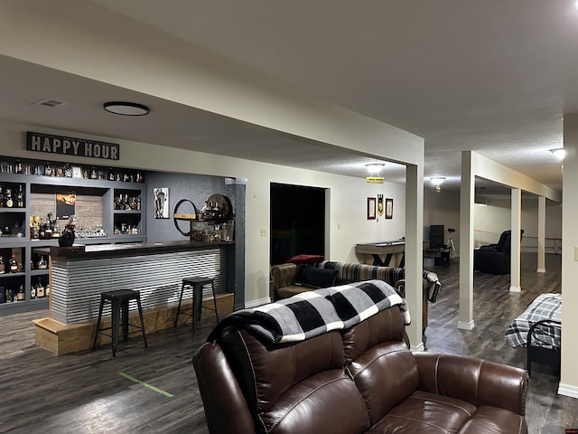 living room with a bar, wood finished floors, and baseboards