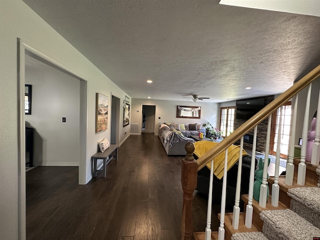 living area with baseboards, stairway, dark wood-style floors, a textured ceiling, and a ceiling fan
