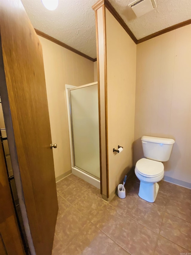 817 Waco St, Camden, AR 71701 - bathroom featuring crown molding, a textured ceiling, a shower stall, toilet, and tile patterned floors