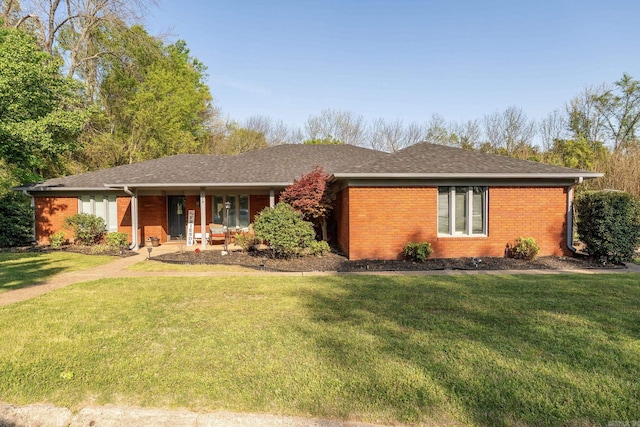 ranch-style house featuring a front yard, brick siding, and a shingled roof