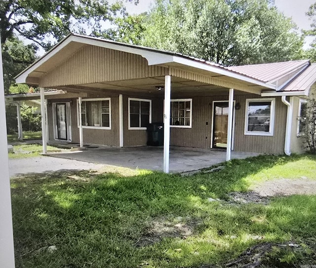 back of house featuring a patio and metal roof