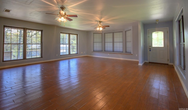 1295 Polk Road 47, Mena, AR 71953 - unfurnished living room with dark wood-type flooring, ceiling fan, baseboards, and visible vents