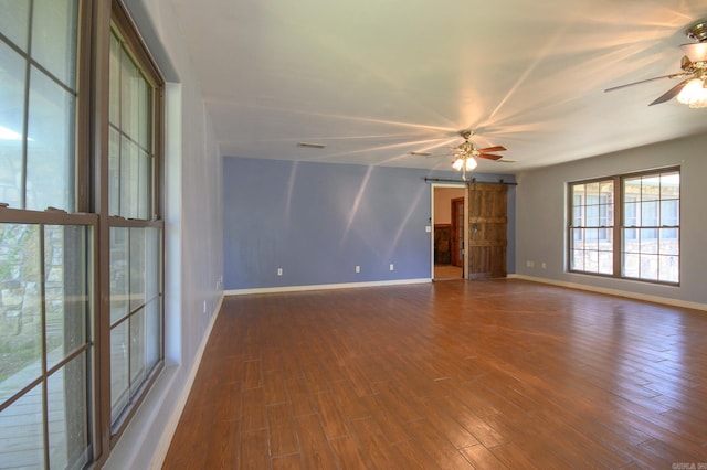 1295 Polk Road 47, Mena, AR 71953 - spare room with ceiling fan, visible vents, a barn door, wood finished floors, and baseboards