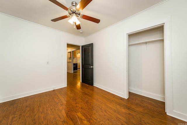 unfurnished bedroom with a closet, baseboards, crown molding, and wood finished floors