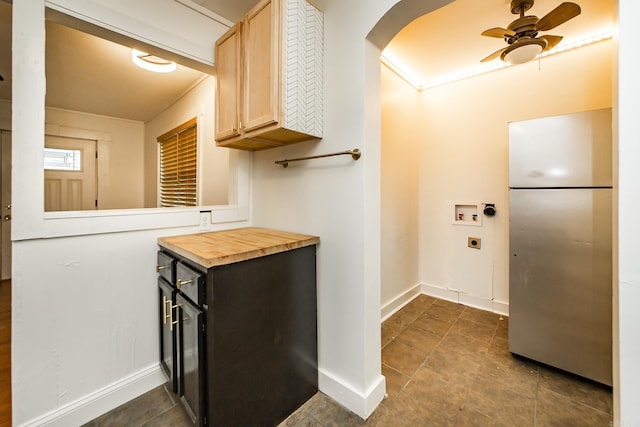 interior space with baseboards, arched walkways, freestanding refrigerator, a ceiling fan, and butcher block countertops