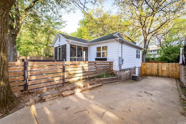 exterior space with a sunroom, fence, and a gate