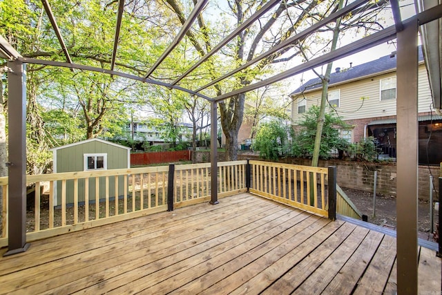 wooden deck featuring fence, an outdoor structure, and a storage unit