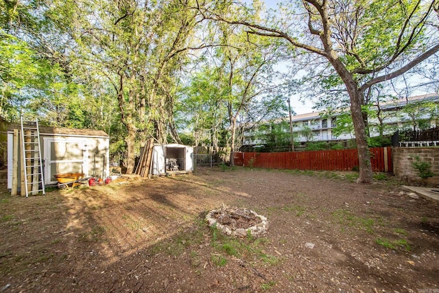 view of yard featuring an outbuilding, fence, and a shed