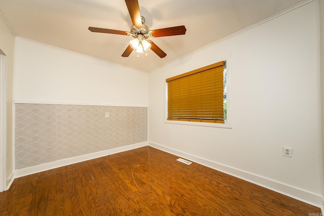 spare room with visible vents, baseboards, ornamental molding, a ceiling fan, and wood finished floors