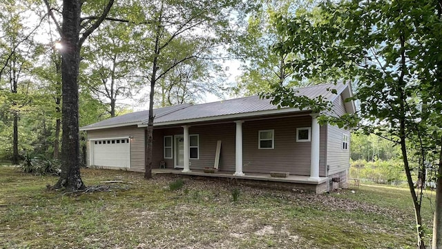 view of front of property featuring a porch, metal roof, and a garage