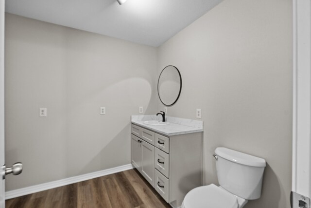 1216 Wade Ave, Judsonia, AR 72081 - bathroom with vanity, baseboards, toilet, and wood finished floors