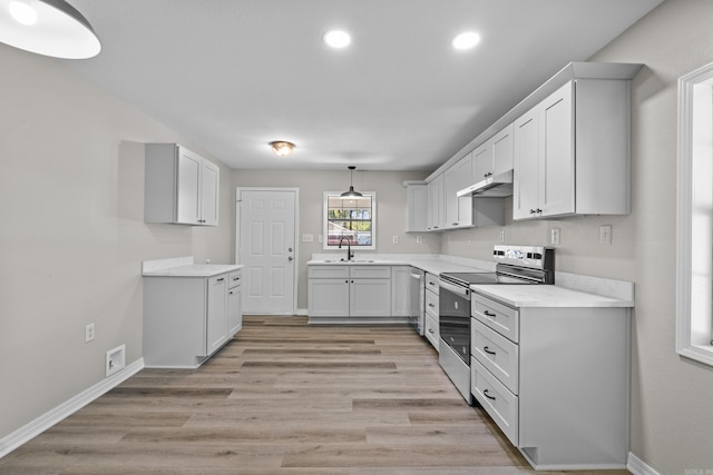 1216 Wade Ave, Judsonia, AR 72081 - kitchen featuring recessed lighting, light countertops, under cabinet range hood, light wood-style floors, and stainless steel appliances