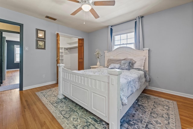 bedroom featuring visible vents, baseboards, multiple windows, and light wood finished floors