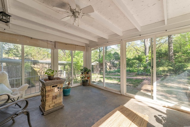 sunroom / solarium featuring beam ceiling and a ceiling fan