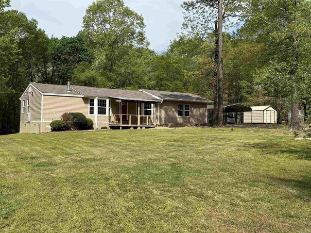 5301 Owensville Cutoff, Lonsdale, AR 72087 - back of house with a carport, a storage shed, a yard, covered porch, and an outdoor structure