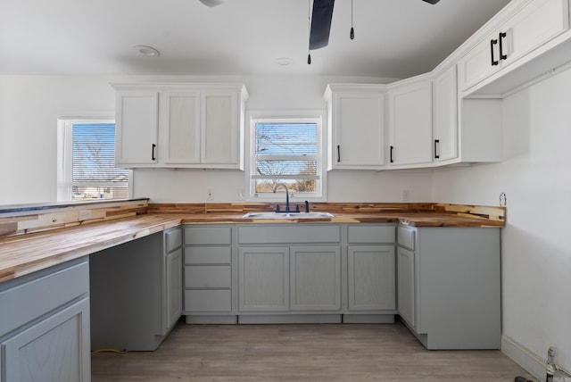 1414 Vine St, North Little Rock, AR 72114 - kitchen featuring butcher block countertops, light wood-style floors, a sink, and a ceiling fan