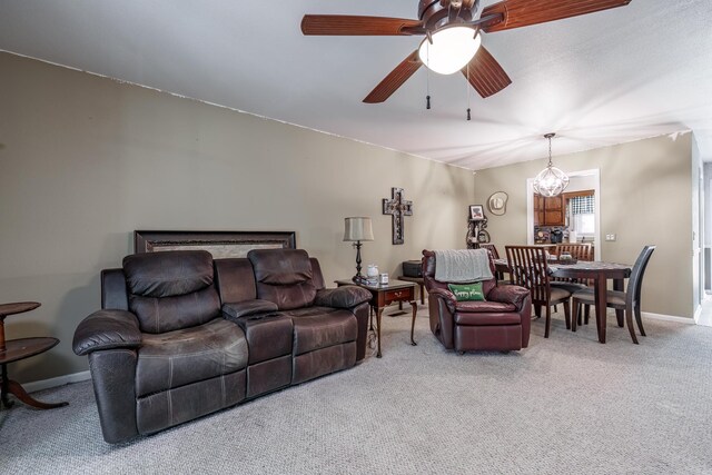 living room featuring baseboards, light colored carpet, and ceiling fan with notable chandelier