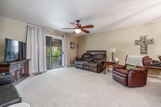 living area featuring carpet, baseboards, and a ceiling fan