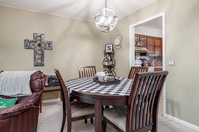 dining space featuring baseboards, an inviting chandelier, and light colored carpet