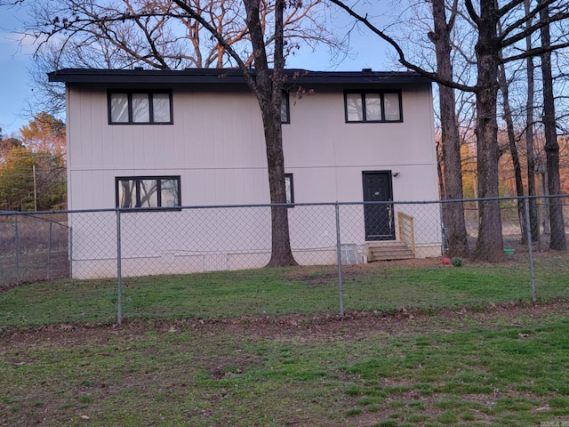 view of side of home with fence and a lawn
