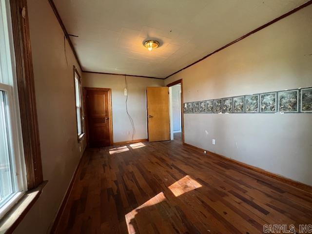 110 Ryerson St, Leachville, AR 72438 - unfurnished bedroom with crown molding, wood finished floors, and baseboards
