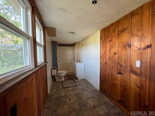 110 Ryerson St, Leachville, AR 72438 - bathroom featuring toilet, stone finish floor, shower / bath combination, and a textured ceiling