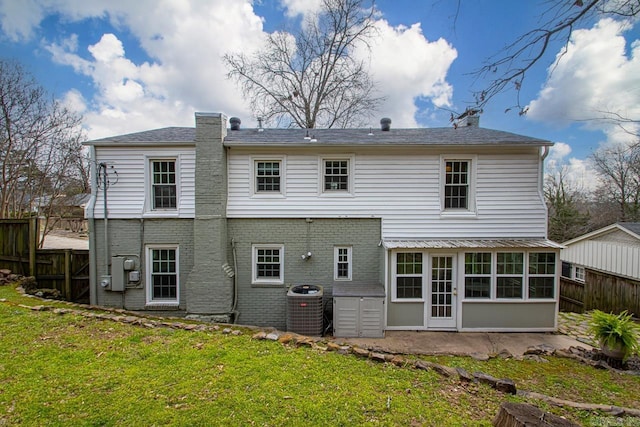 5400 Southwood Rd, Little Rock, AR 72205 - rear view of house featuring central AC unit, brick siding, fence, and a lawn