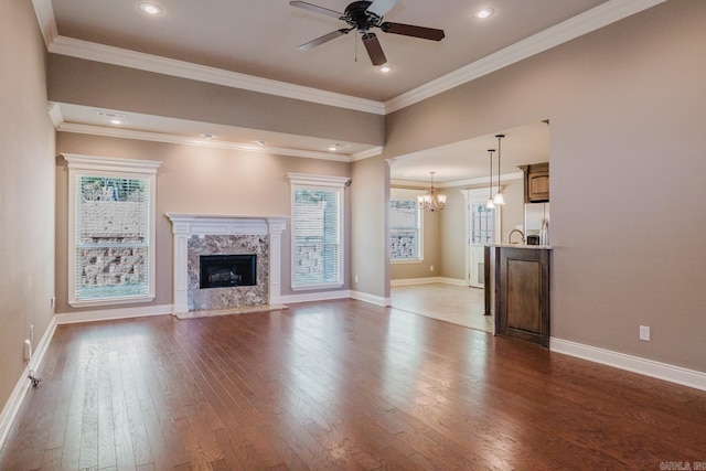 1844 White Oak Cir, Benton, AR 72019 - unfurnished living room featuring a fireplace, plenty of natural light, wood finished floors, and ceiling fan with notable chandelier