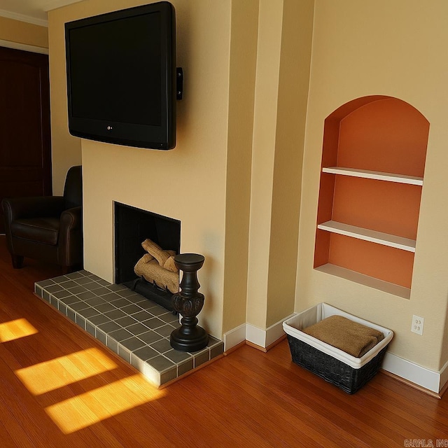 interior space with baseboards, built in features, and wood finished floors