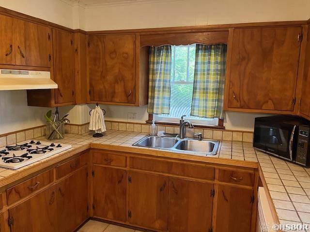 kitchen featuring white gas cooktop, black microwave, tile countertops, and under cabinet range hood