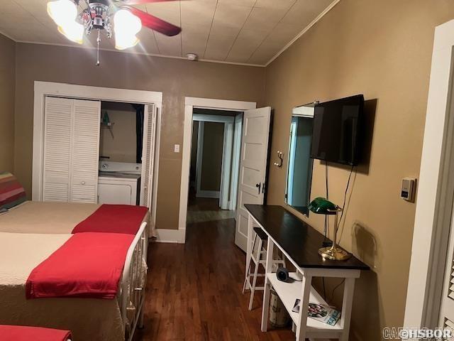 bedroom featuring dark wood-type flooring, a closet, crown molding, and a ceiling fan