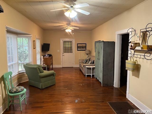interior space with baseboards, a ceiling fan, and wood finished floors