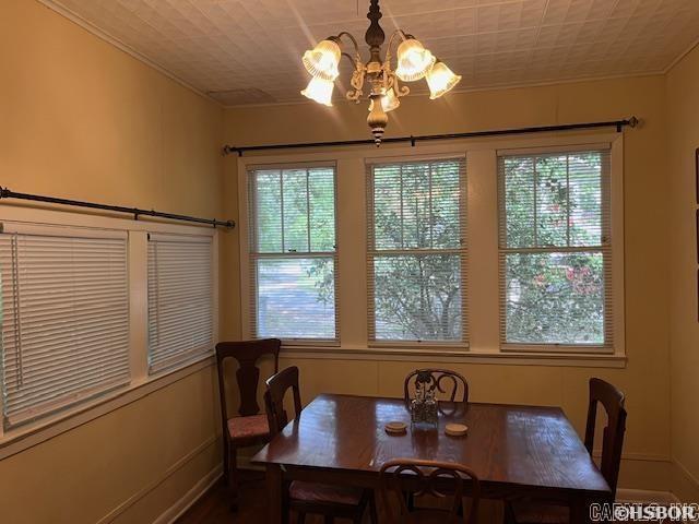 dining room with baseboards, an inviting chandelier, and crown molding