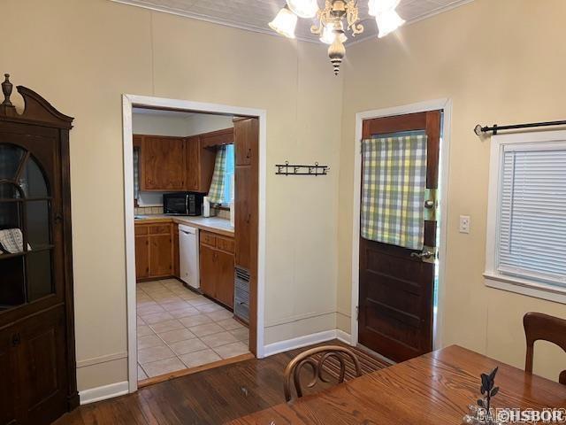 foyer entrance with light wood-style flooring, baseboards, a chandelier, and crown molding