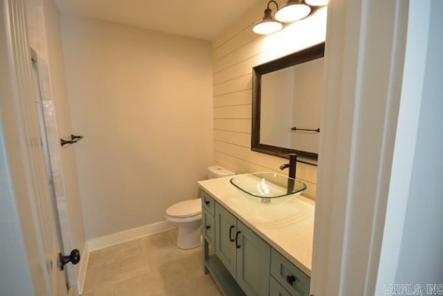 12904 Southridge Dr, Little Rock, AR 72212 - bathroom featuring vanity, toilet, wood walls, and baseboards