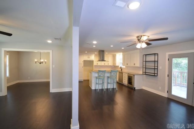 12904 Southridge Dr, Little Rock, AR 72212 - unfurnished living room featuring a ceiling fan, beverage cooler, dark wood-type flooring, baseboards, and a chandelier