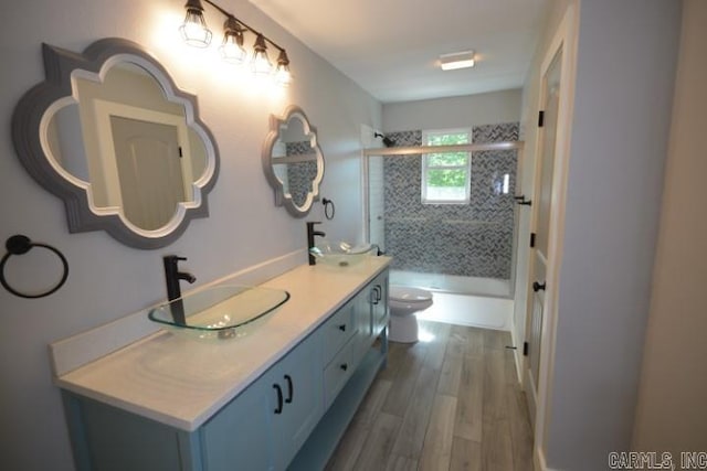 12904 Southridge Dr, Little Rock, AR 72212 - full bath featuring toilet, double vanity, wood finished floors, and combined bath / shower with glass door